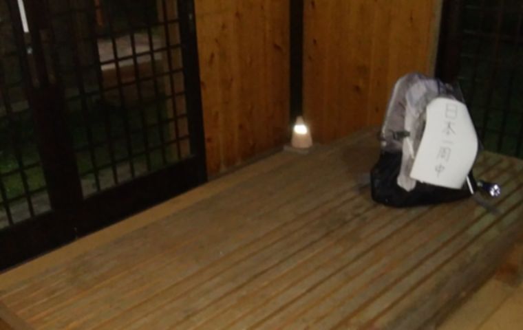 バス停のベンチに置かれた、日本一周の看板が付いたバックパック